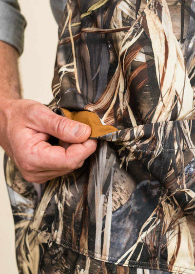 closeup of a hand showing the interior lining of a pocket on a camo apron